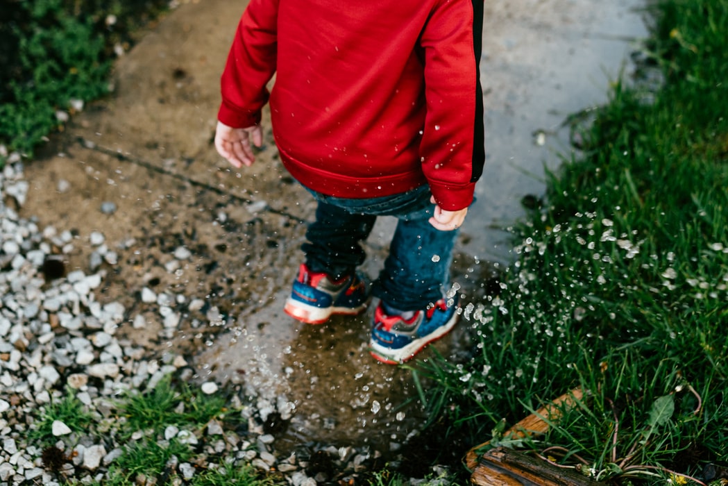 kid jumping in a puddle